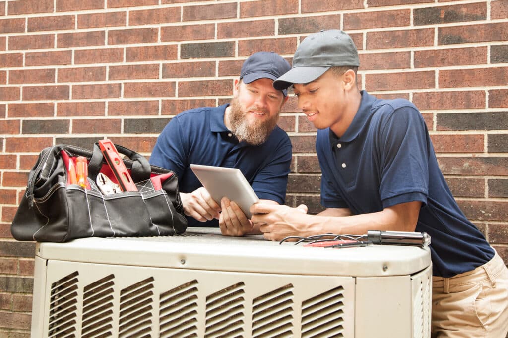 hvac-repair-techs-assess-ac-unit-539104584